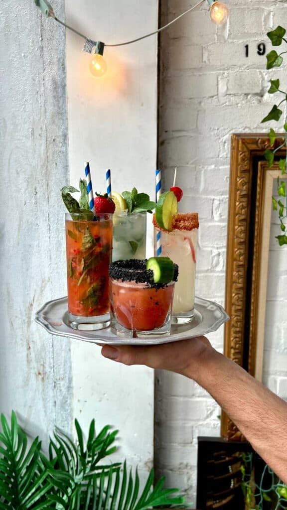 there are three different drinks on a tray with strawberries and lime