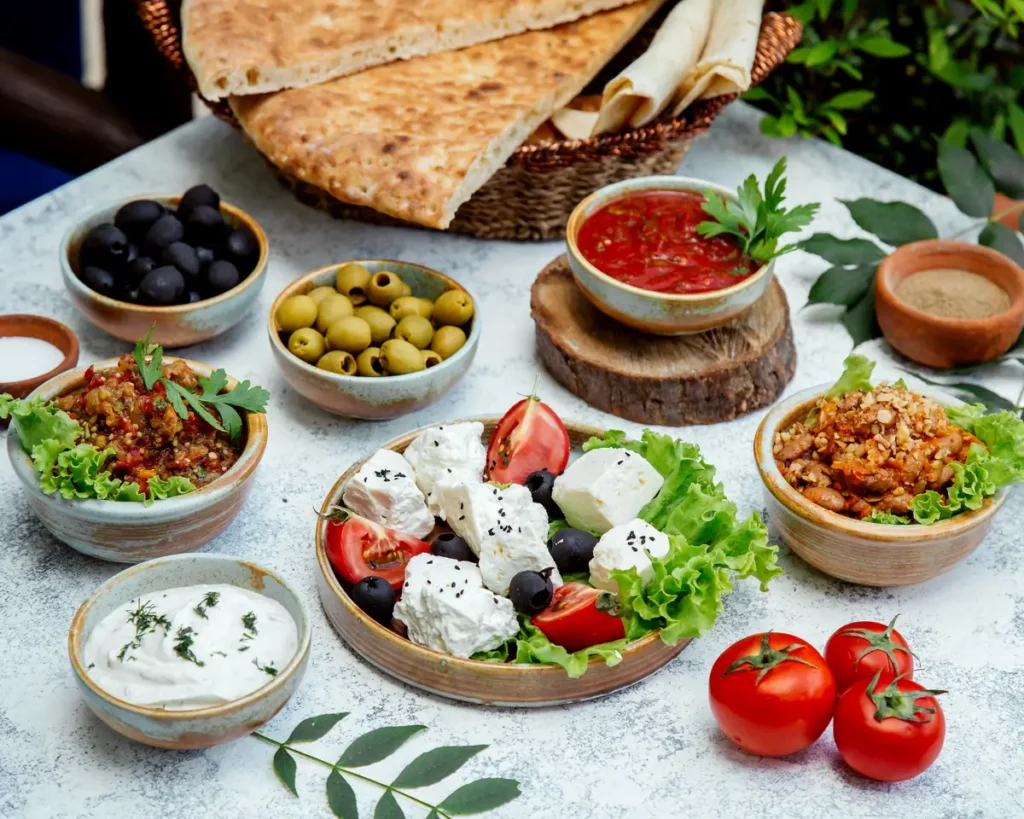 there are many bowls of food on a table with pita bread