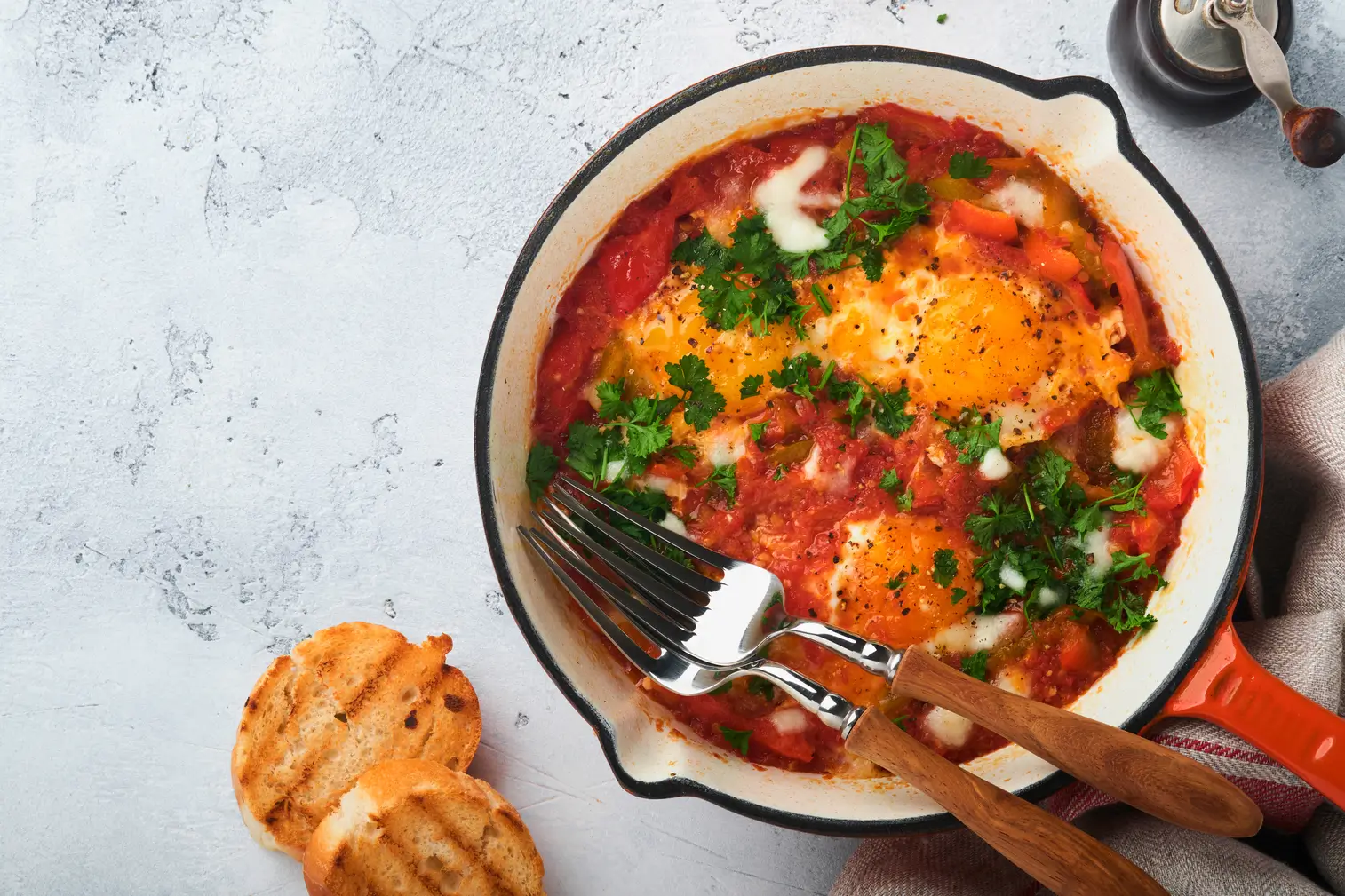 someone is holding a fork and a pan with a dish of eggs