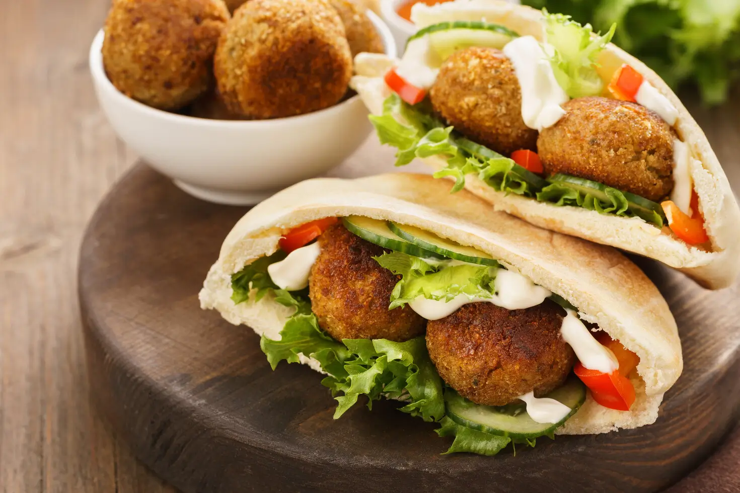 there is a pita sandwich with meatballs and lettuce on it