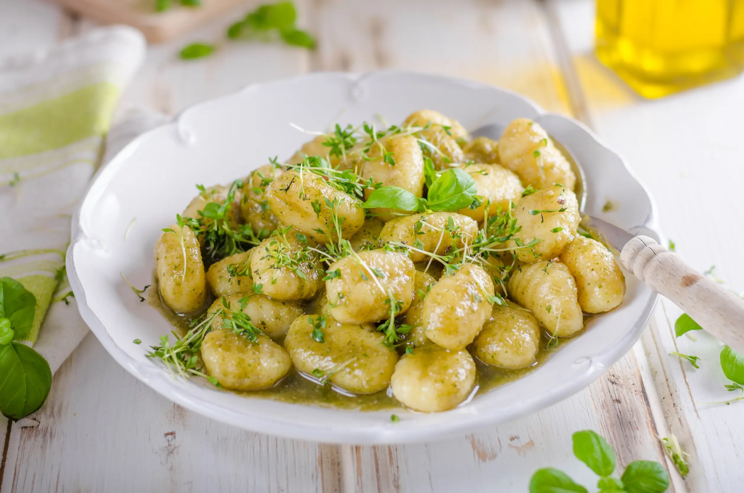 there is a bowl of gnocchini with a spoon on a table