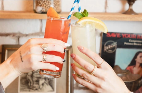 someone holding a glass of juice and a drink with a straw