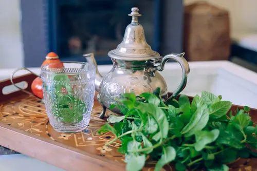 there is a tray with a tea pot and a glass on it