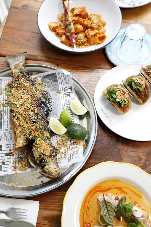 there are many plates of food on a table with silverware