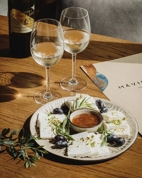 there is a plate of cheese and wine on a table