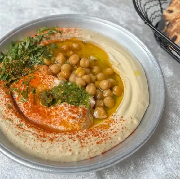 a close up of a plate of hummusle and pita bread