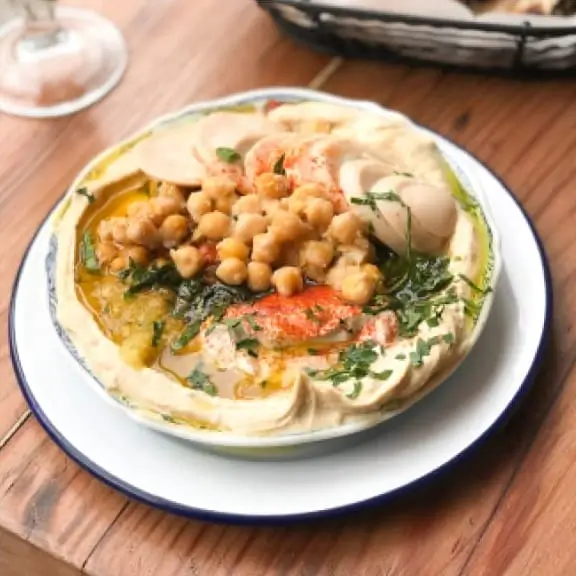there is a plate of food that includes hummus and chickpeas