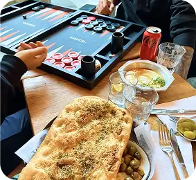 there are two people sitting at a table with a board game