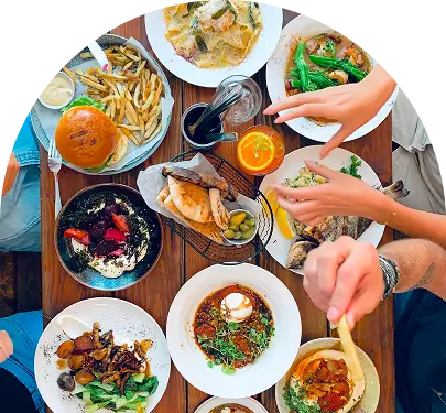 several people are eating a meal at a table with plates of food