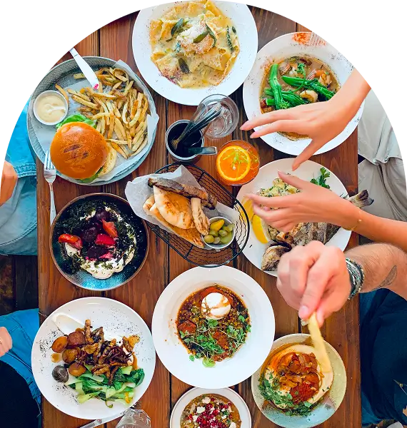 several people are eating a meal at a table with plates of food