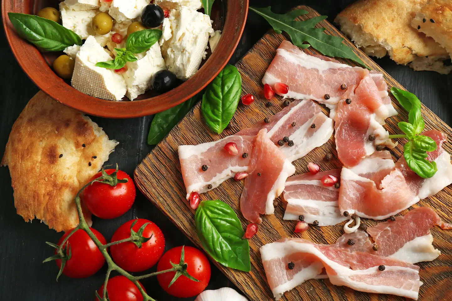 a close up of a cutting board with meat and vegetables on it