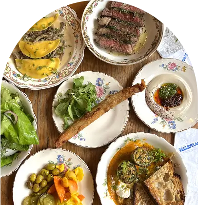 several plates of food are arranged on a wooden table