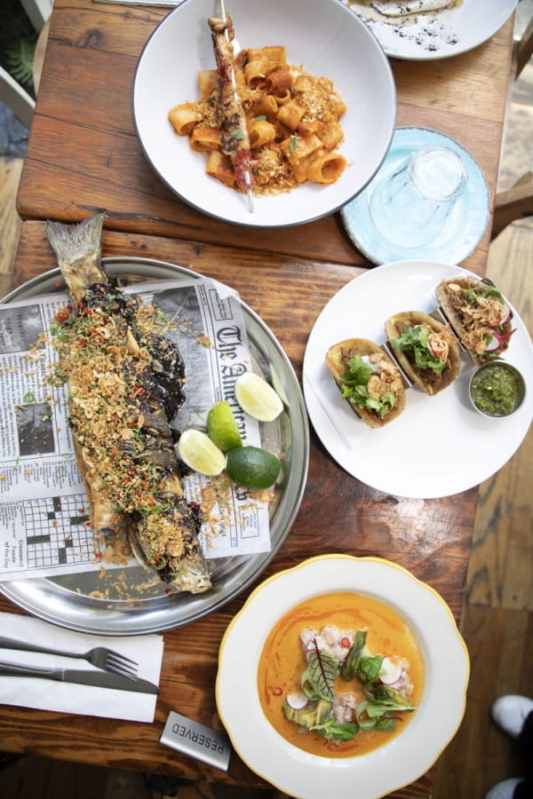 there are many plates of food on a table with silverware