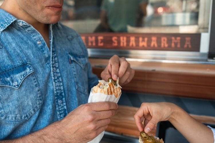 there is a man and a woman eating food at a table