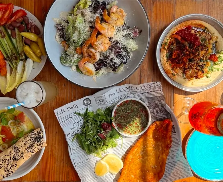 several plates of food are on a table with a newspaper