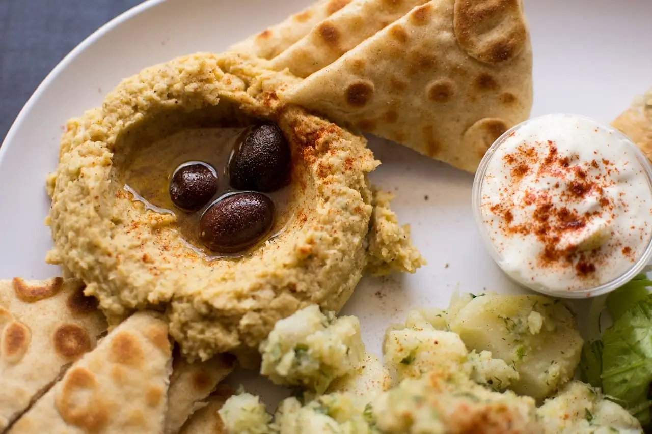 there is a plate of food with pita bread, salad and pita chips