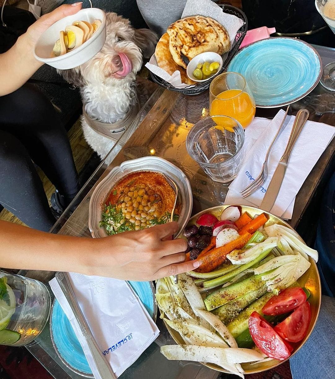 people sitting at a table with plates of food and drinks