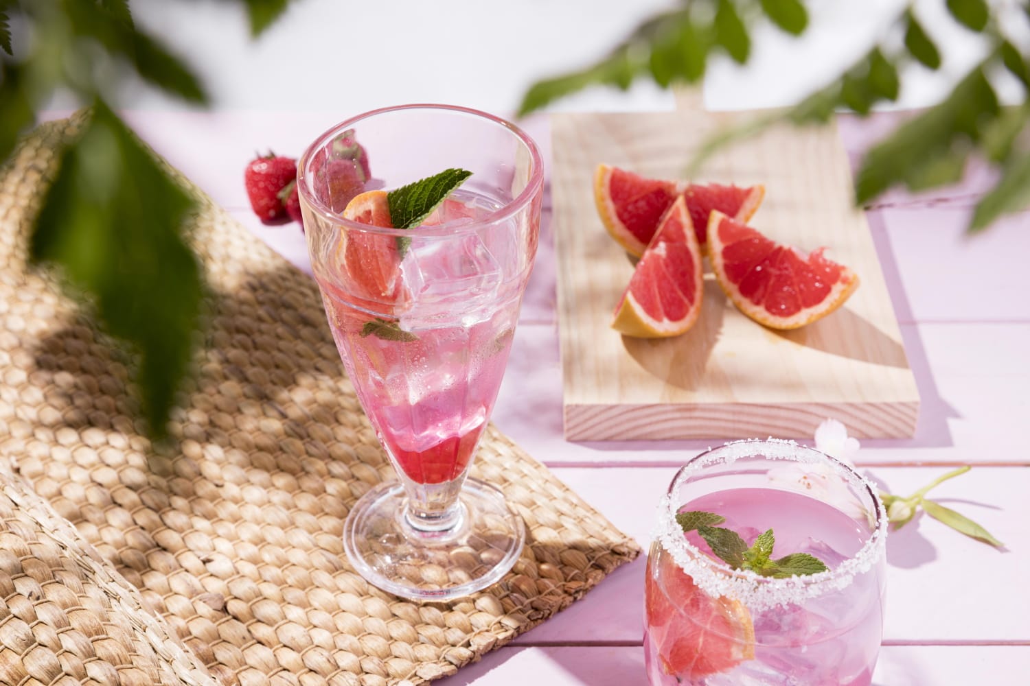 there are two glasses of water and a glass of fruit on a table