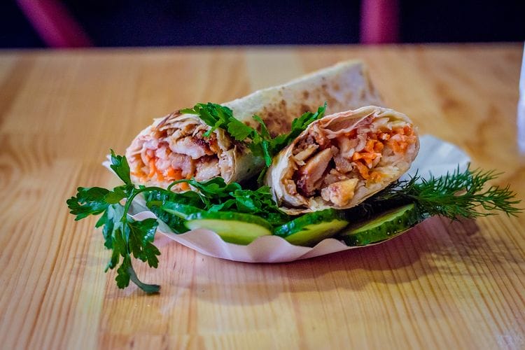 there is a plate with a wrap and a salad on it