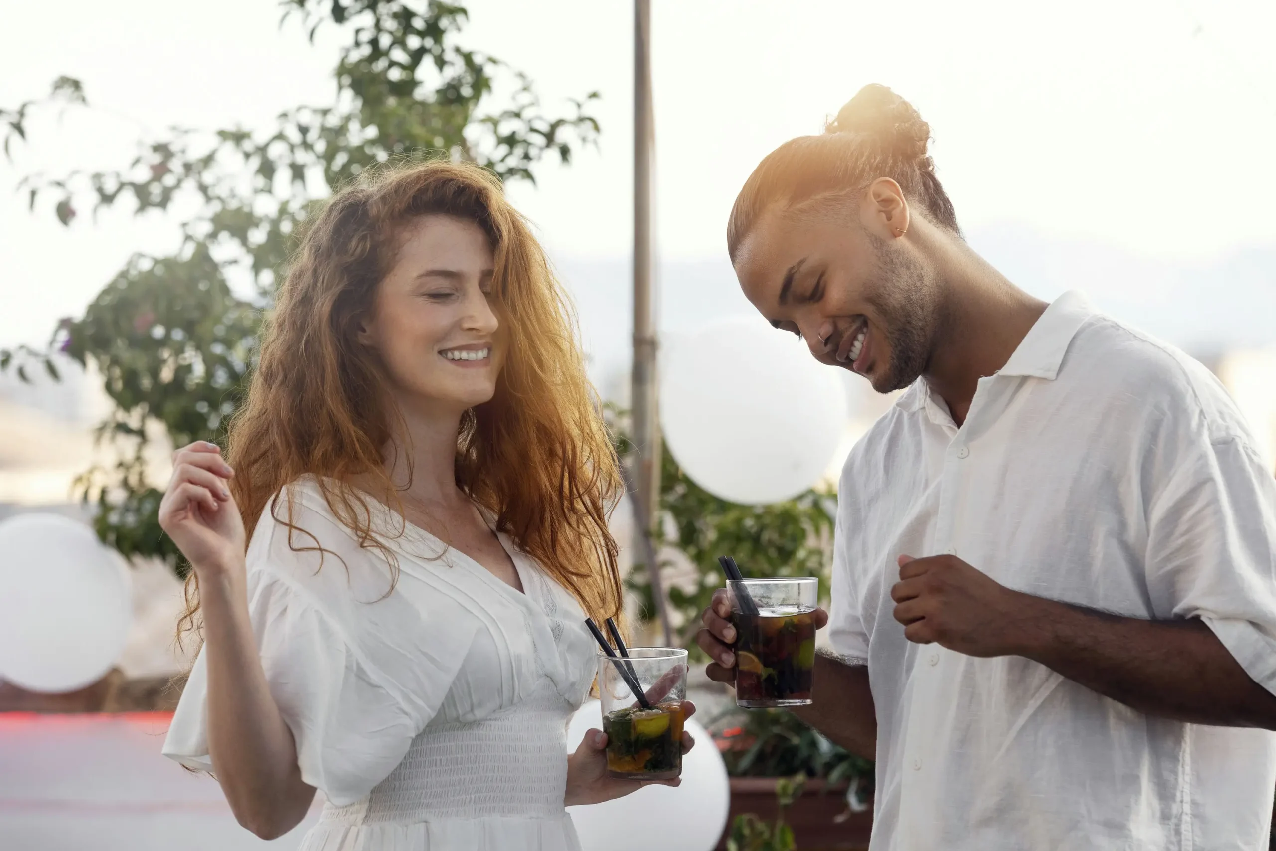 there are two people standing together and drinking drinks