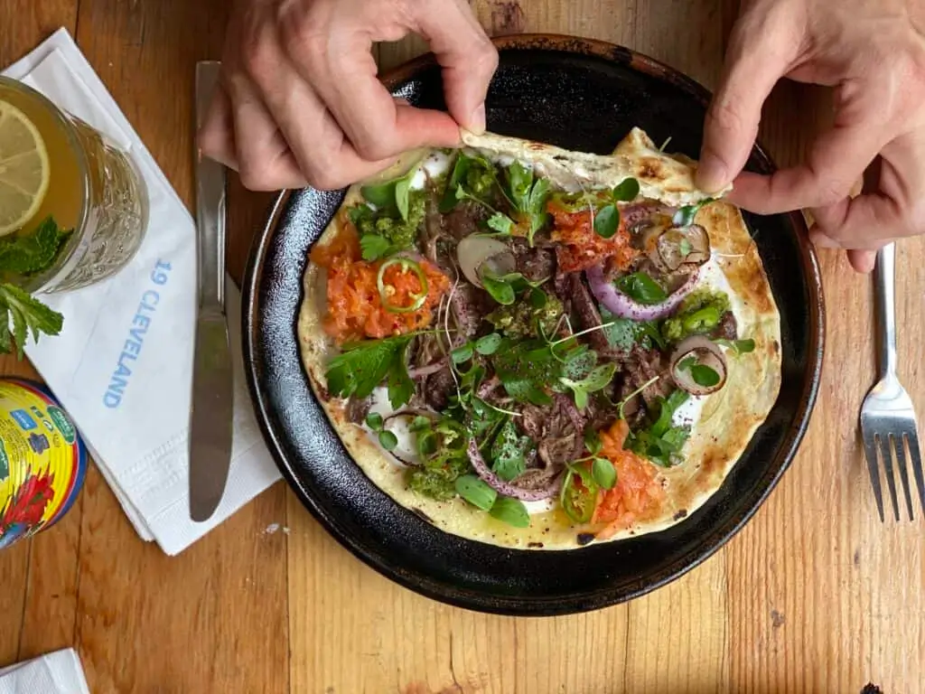 someone is putting toppings on a pizza on a pan