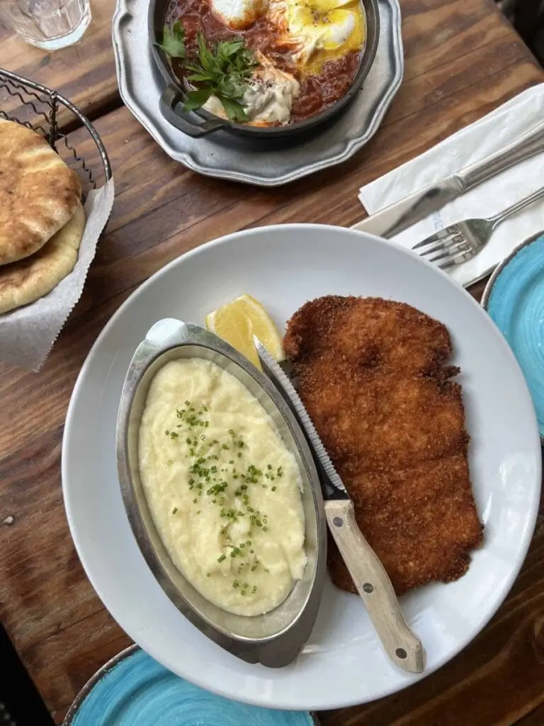there is a plate of food on a table with a bowl of soup