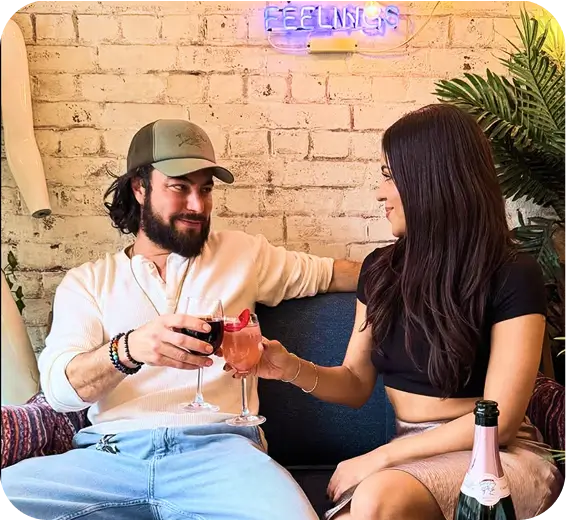 they are sitting on a couch with a glass of wine