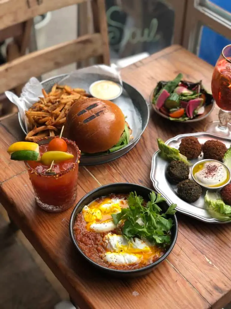 there are many plates of food on the table with drinks