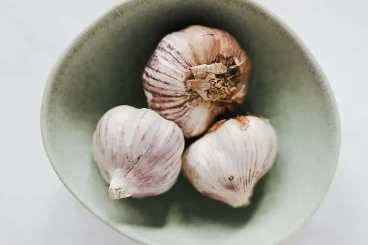 arafed garlic in a bowl on a white table