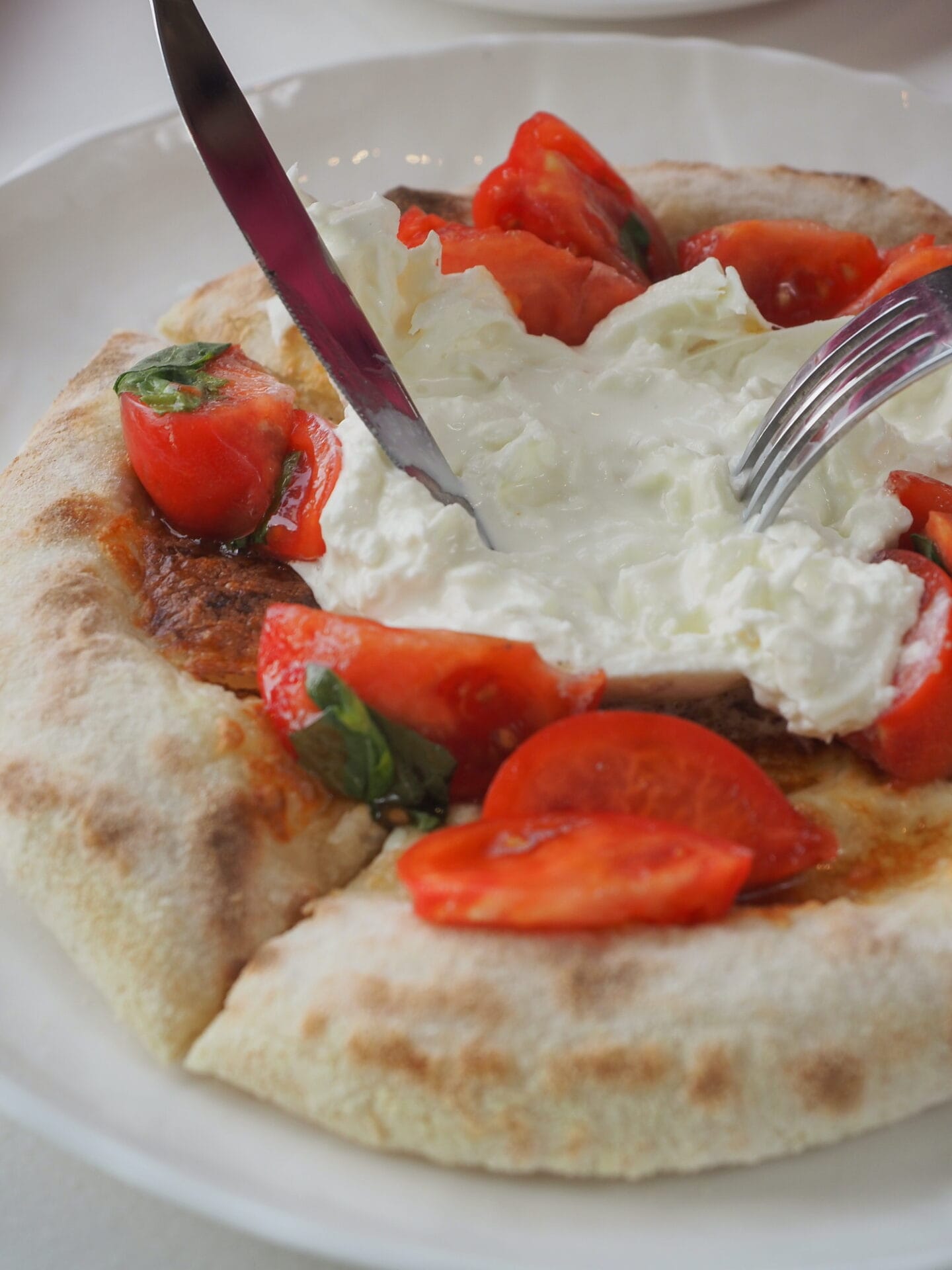 there is a pizza with tomatoes and cheese on a plate