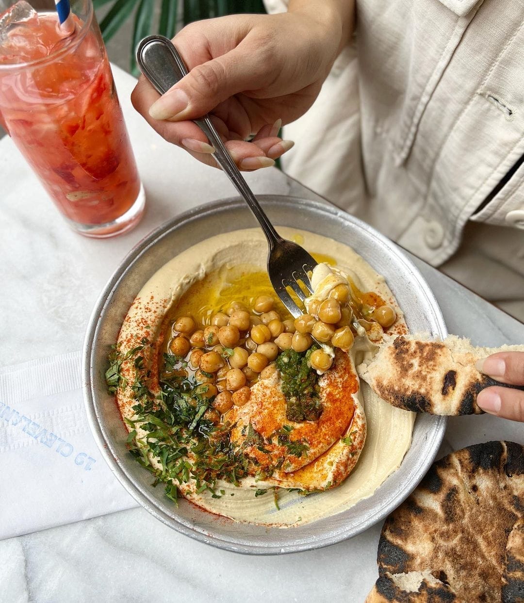 someone is eating a bowl of hummus and pita bread