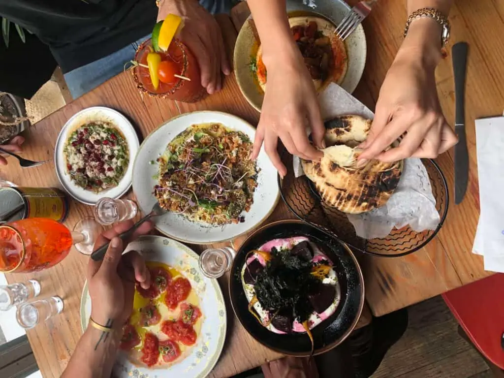 several people are sitting at a table with plates of food