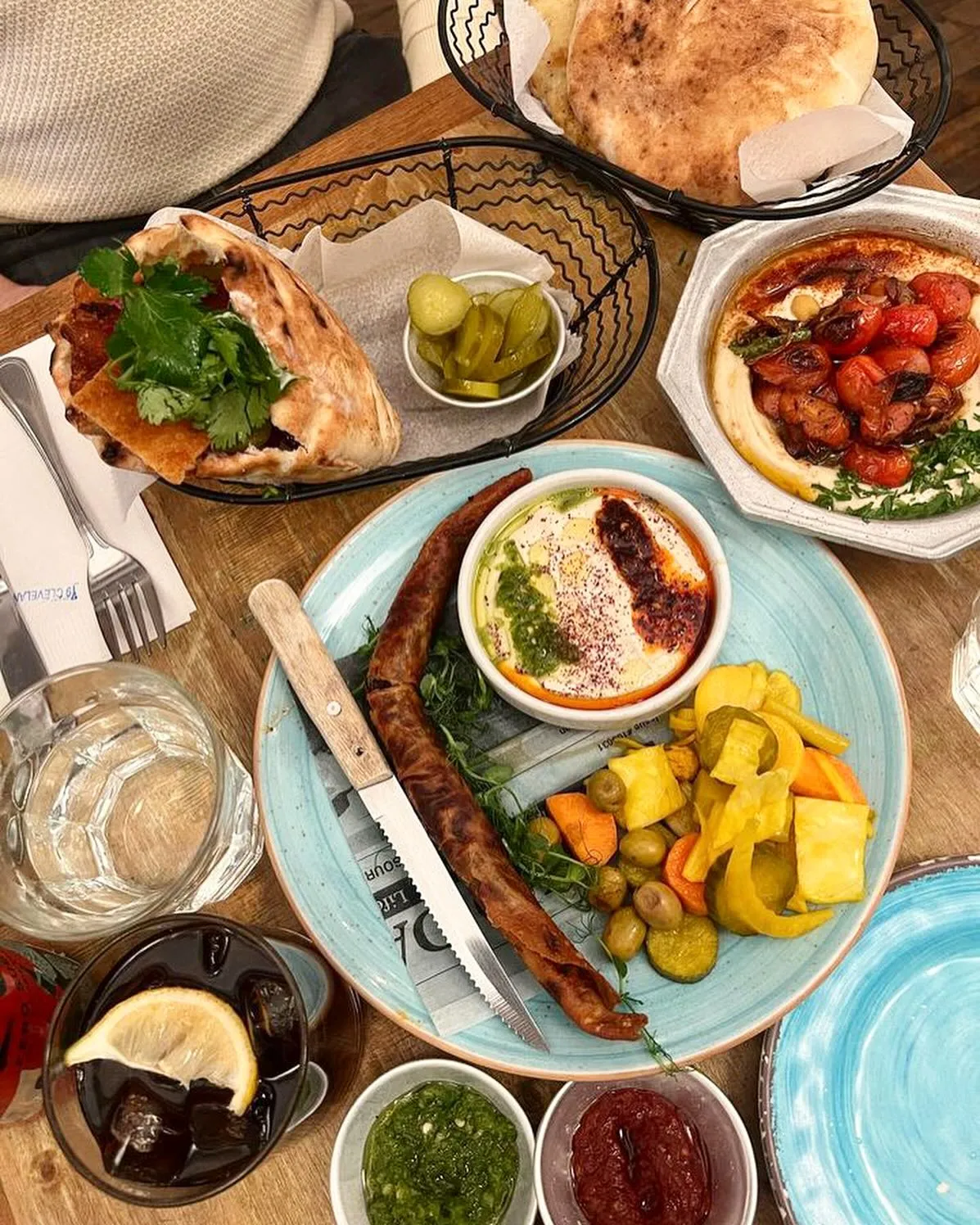 Mediterranean spread with pita, sausage, hummus, pickles, and dips