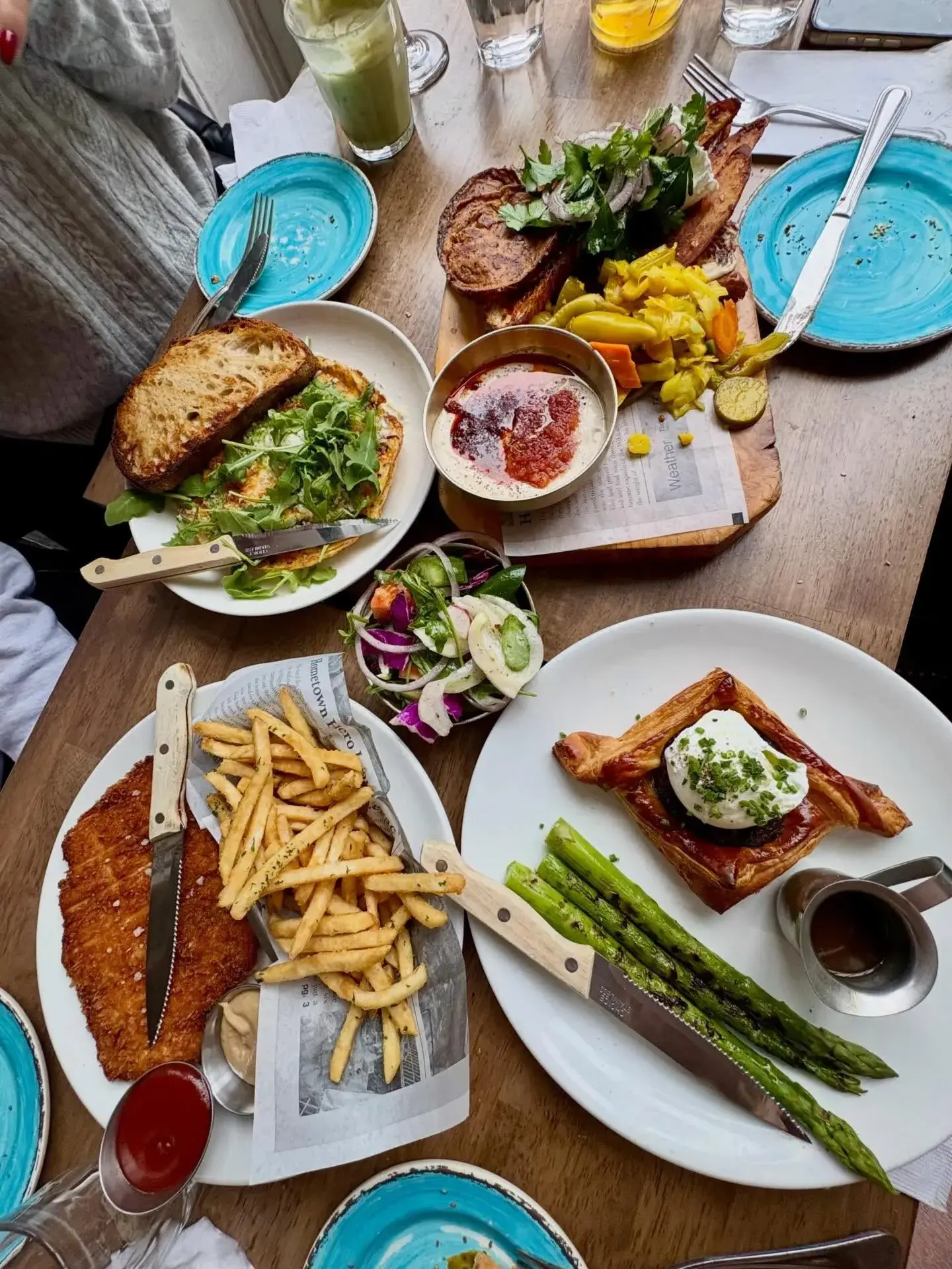 Mediterranean brunch spread with fries, asparagus, eggs, and shared plates