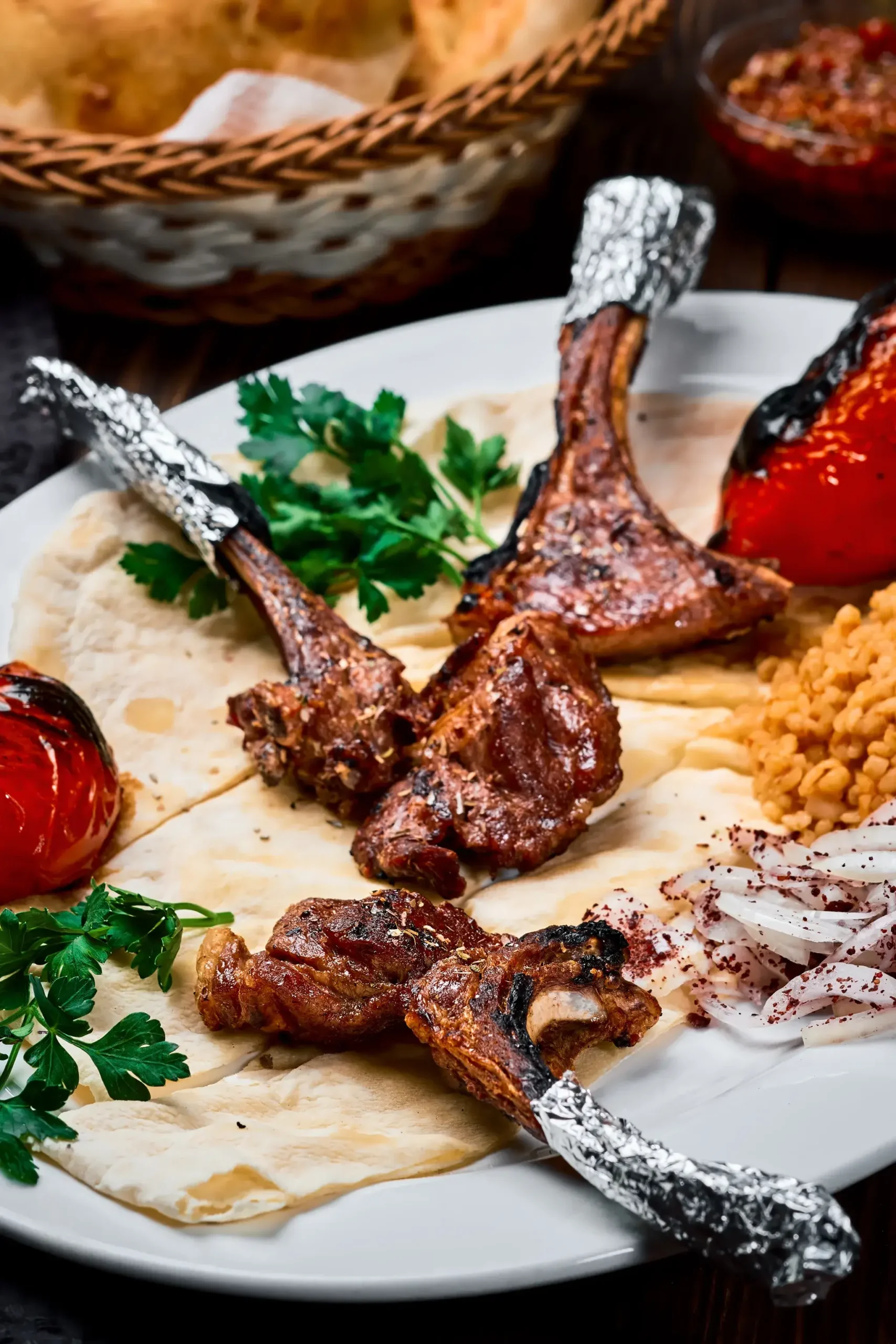 Greek lamb chops with hummus and fattoush on a shared table